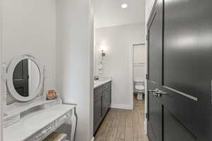 Bathroom featuring wood tiled floors, vanity, and recessed lighting