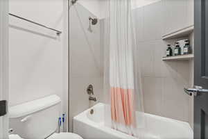 Full bath with shower / bathtub combination with curtain and toilet