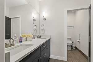Full bathroom featuring double vanity and wood tiled floors