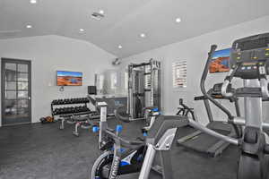 Gym with vaulted ceiling and recessed lighting