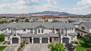 View of front of house featuring driveway, a residential view, a mountain view, and stucco siding