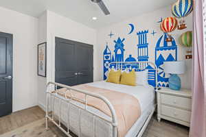 Bedroom with light wood-style flooring, ceiling fan, a closet, and recessed lighting