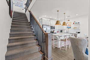 Stairway with carpted floors and recessed lighting