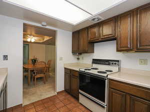 Kitchen featuring electric stove, light tile patterned floors, light countertops.