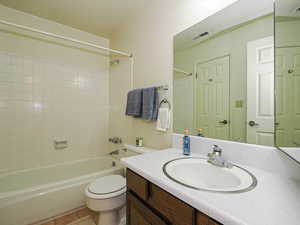Bathroom featuring shower / tub combination, vanity, and tile patterned flooring