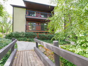View of wooden deck overlooking lush greenery.