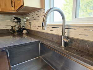 Kitchen view of backsplash and dark stone counters