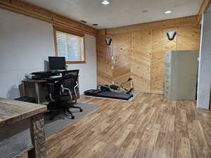 Office with wooden walls and light wood-type flooring
