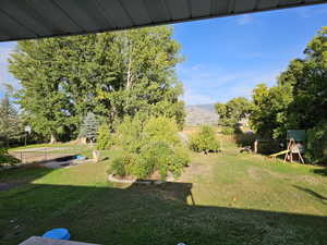 View of yard featuring a playground and view of wooded area