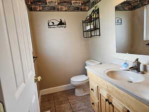 Bathroom featuring vanity and dark tile patterned floors