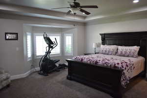 Primary bedroom featuring ceiling fan, a tray ceiling, and recessed lighting