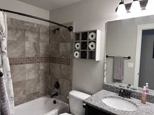 Full Bathroom with tiled tub surround, cast iron tub and granite countertop