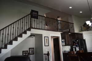 Stairway featuring a high ceiling and recessed lighting