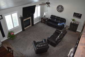 Living room with a tile fireplace, a ceiling fan