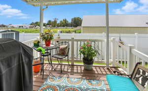 View of wooden balcony featuring area for grilling and a deck