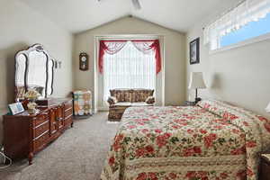 Bedroom featuring carpet, lofted ceiling, and a ceiling fan