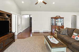 Living area with arched walkways, recessed lighting, a ceiling fan, lofted ceiling, and dark wood-style floors