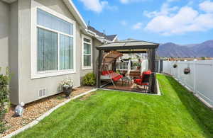 Fenced backyard with a gazebo, a patio, and a mountain view