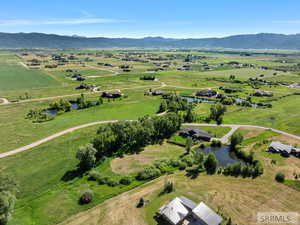 Aerial view of sparsely populated area with agricultural land and a water and mountain view