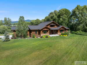 View of front facade with a front lawn, a porch, and stone siding