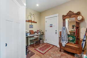 Foyer entrance with light tile patterned floors and recessed lighting