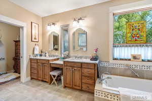 Bathroom with two vanities, a garden tub, and light tile patterned flooring