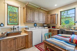 Laundry room featuring washer and dryer, cabinet space, light tile patterned flooring, and recessed lighting