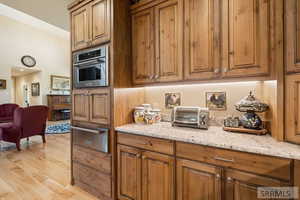 Kitchen featuring brown cabinets, light wood finished floors, and a warming drawer
