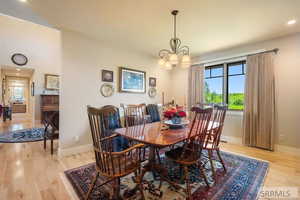Dining room featuring light wood finished floors, healthy amount of natural light, a chandelier, and recessed lighting