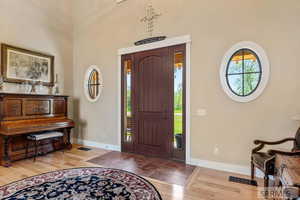 Foyer with light wood finished floors and a high ceiling