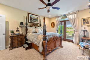 Bedroom featuring access to outside, carpet flooring, and ceiling fan