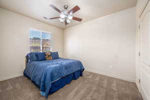 Carpeted bedroom featuring baseboards and a ceiling fan
