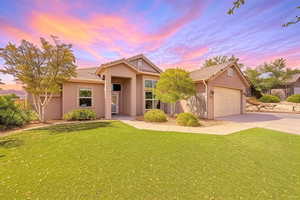 Ranch-style home featuring concrete driveway, a yard, a tile roof, and stucco siding
