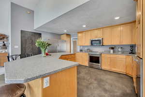 Kitchen with custom concrete floors, refrigerator, freezer, and induction oven