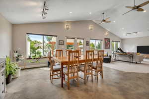 Dining area with custom concrete floors, vaulted ceilings, and natural light