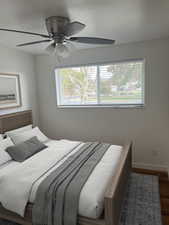1st Bedroom featuring multiple windows, ceiling fan, and wood finished floors