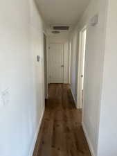 Hall with dark wood finished floors and baseboards