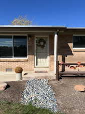 Doorway to property featuring brick siding