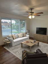 Living room featuring wood finished floors and a ceiling fan