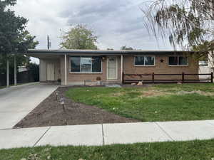 Single story home with brick siding, concrete driveway, and an attached carport