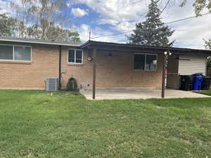 View of home's exterior featuring a patio, brick siding, and a yard
