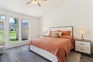 Bedroom with lofted ceiling, dark wood-style flooring, and ceiling fan
