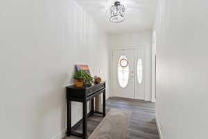 Entryway with baseboards and dark wood-style floors