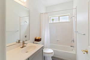 Bathroom with shower / bathtub combination with curtain and vanity