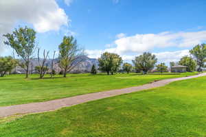 Surrounding community with a yard and a mountain view