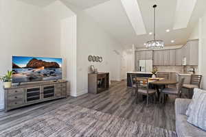 Dining room featuring arched walkways, recessed lighting, dark wood-style floors, and a chandelier