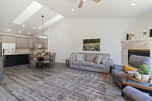 Living room with recessed lighting, dark wood-style flooring, high vaulted ceiling, a ceiling fan, and a chandelier