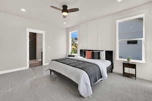 Bedroom featuring light carpet, recessed lighting, connected bathroom, a ceiling fan, and a decorative wall
