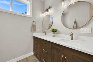 Bathroom with double vanity and light wood-style floors
