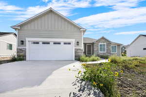 Craftsman house featuring stone siding, board and batten siding, concrete driveway, and a garage